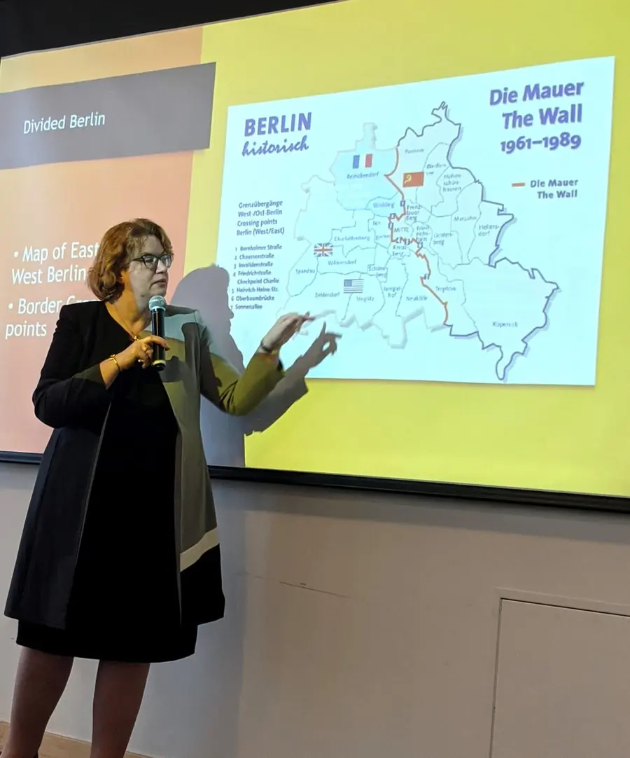 Christiane presenting a map of divided Berlin during a talk